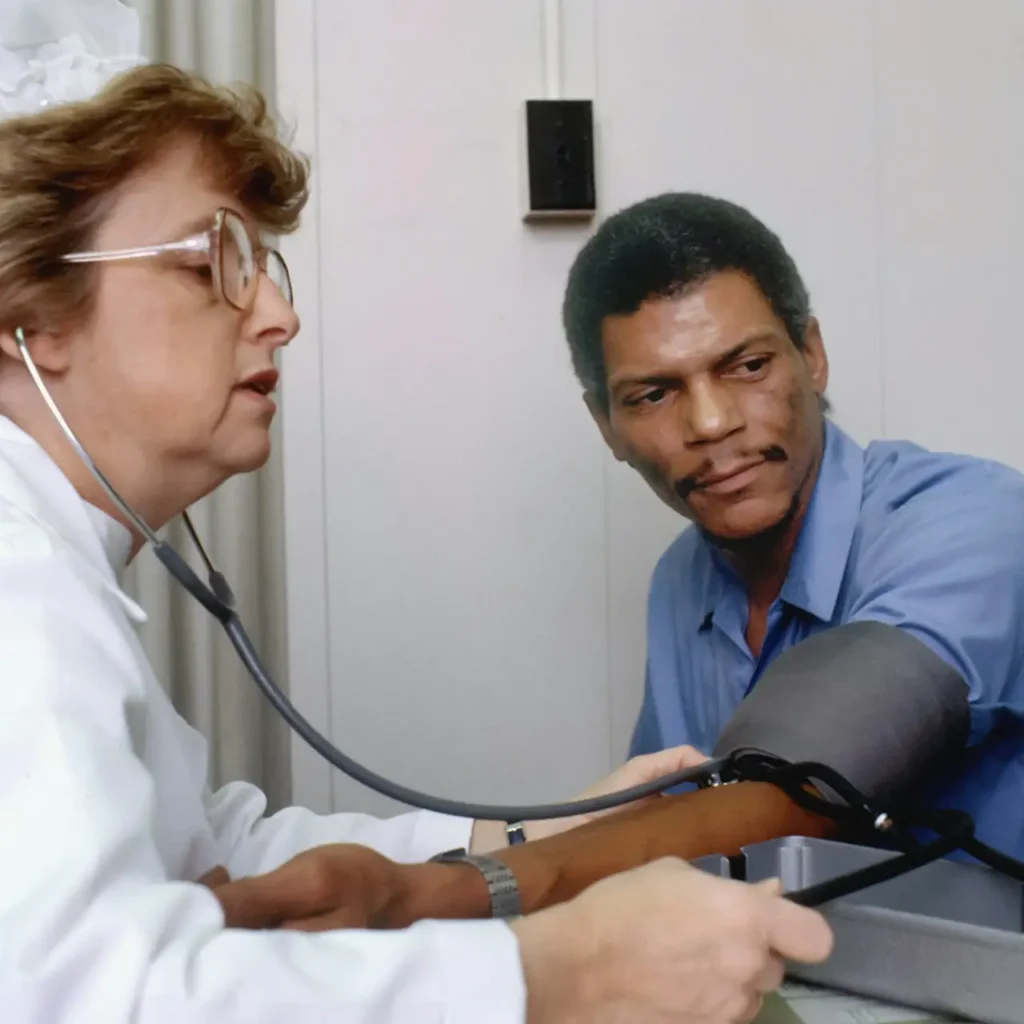 Médecin contrôlant la tension artérielle d'un patient lors d'une consultation pour apnée du sommeil et hypertension