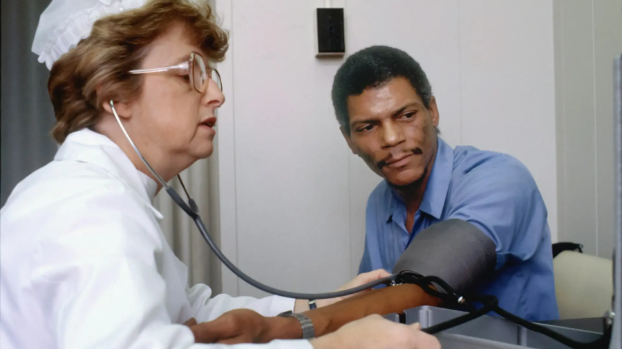 Médecin contrôlant la tension artérielle d'un patient lors d'une consultation pour apnée du sommeil et hypertension
